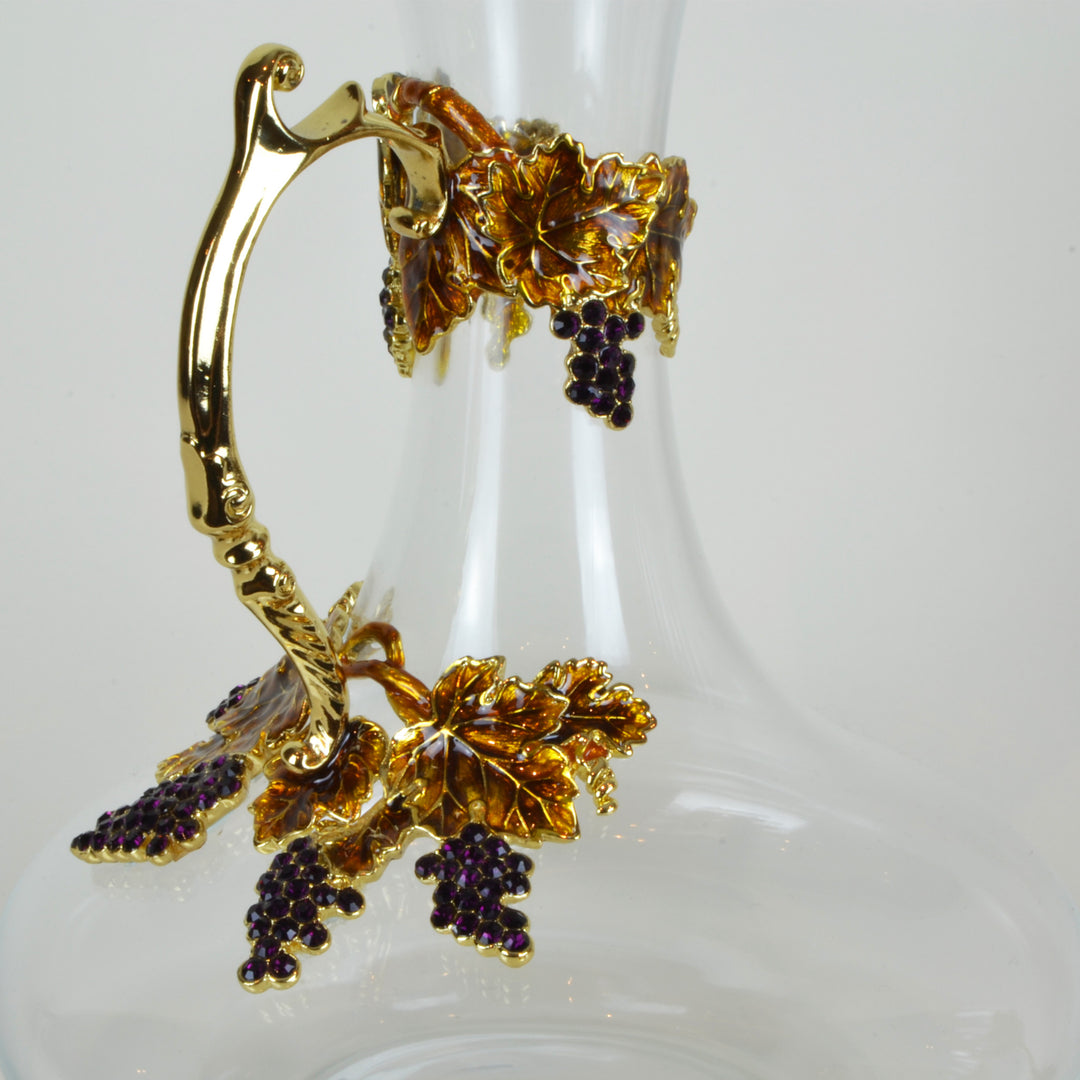 Amber Wine Carafe Detail - Glassware set. Set includes 1x Carafe and 4x Wine Glasses. Gold and Amber colour. Intricate metal and natural stone vine leaves detail. Natural Amber material and Swarovski coloured crystals.  Materials: High Grade Glass, Brass,